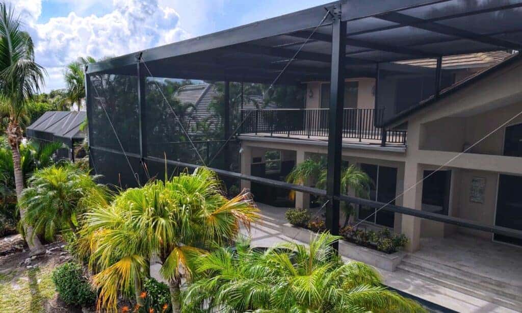 Two story flat roof pool cage enclosure with second floor balcony railing in Longboat Key Florida