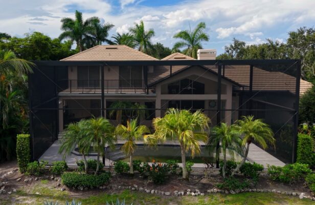 Two story flat roof pool cage enclosure with transom walls and second story balcony railing in Longboat Key Florida