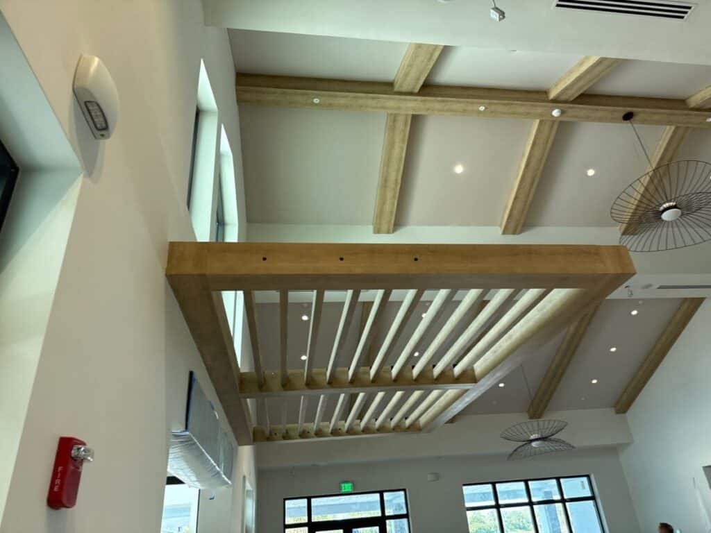 Custom welded aluminum pergola slat canopy installed inside a commercial building, providing architectural shade, airflow, and modern design in Florida