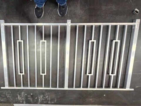 Custom welded aluminum vertical railing panels with decorative pickets fabricated in shop for residential installation in Florida