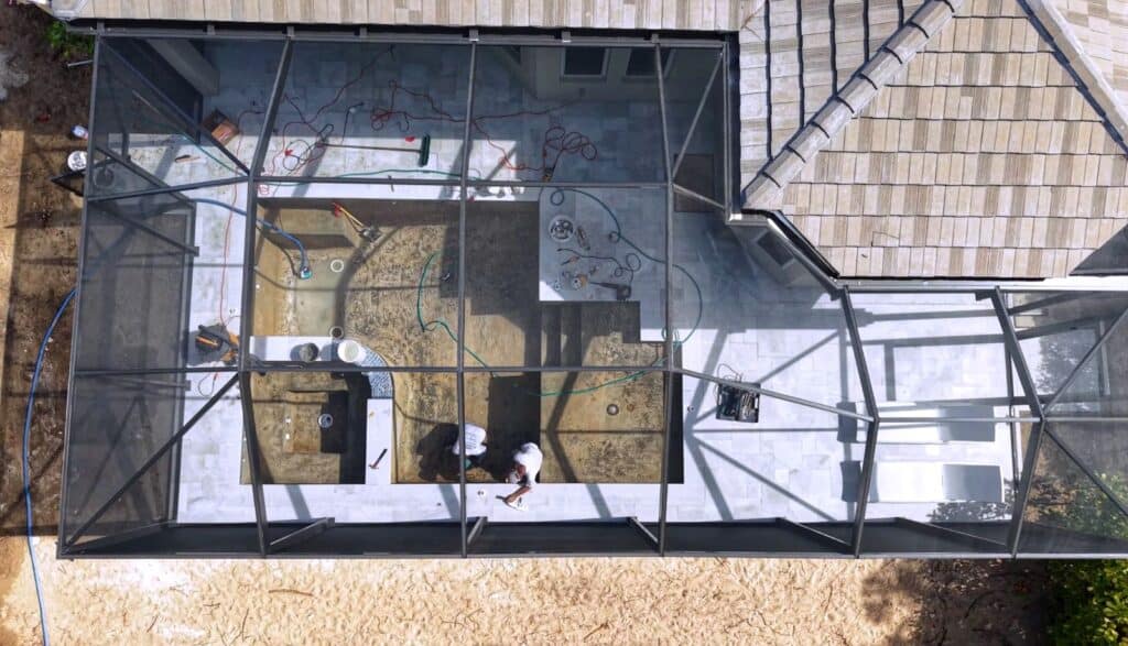 Aerial view of a finished rescreen on an existing pool enclosure completed during a deck and pool renovation