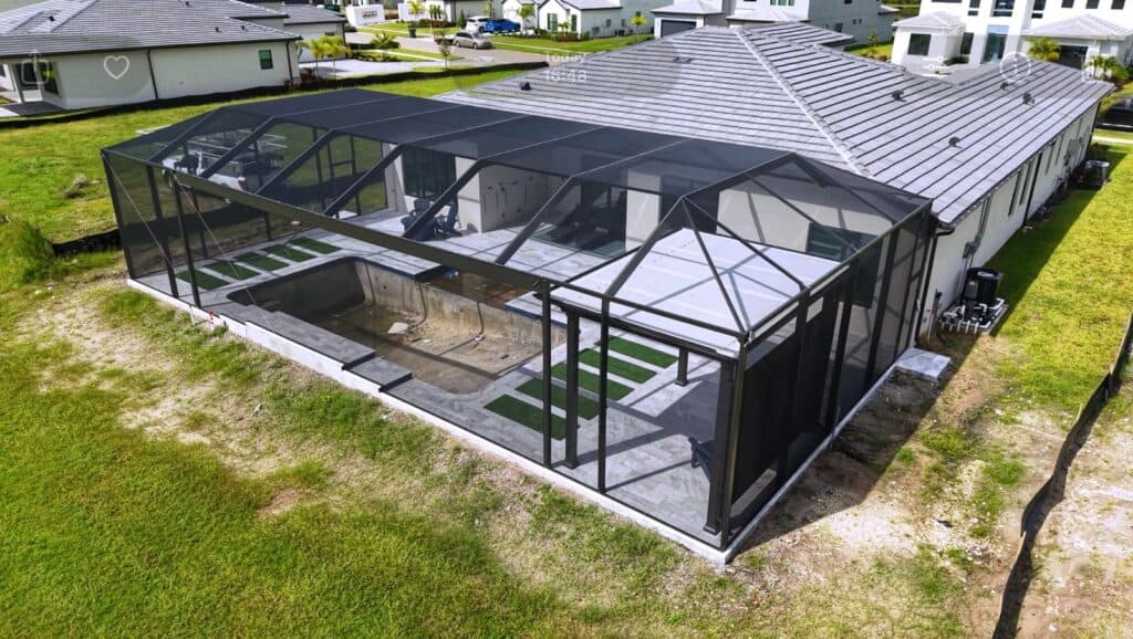 Aerial view of a new pool enclosure with a covered pergola structure built inside the screened area in Florida