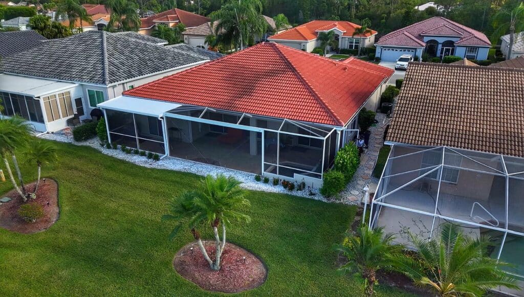 Composite roof pool cage enclosure with gable roof design and large picture window in Heron's Glen North Fort Myers Florida