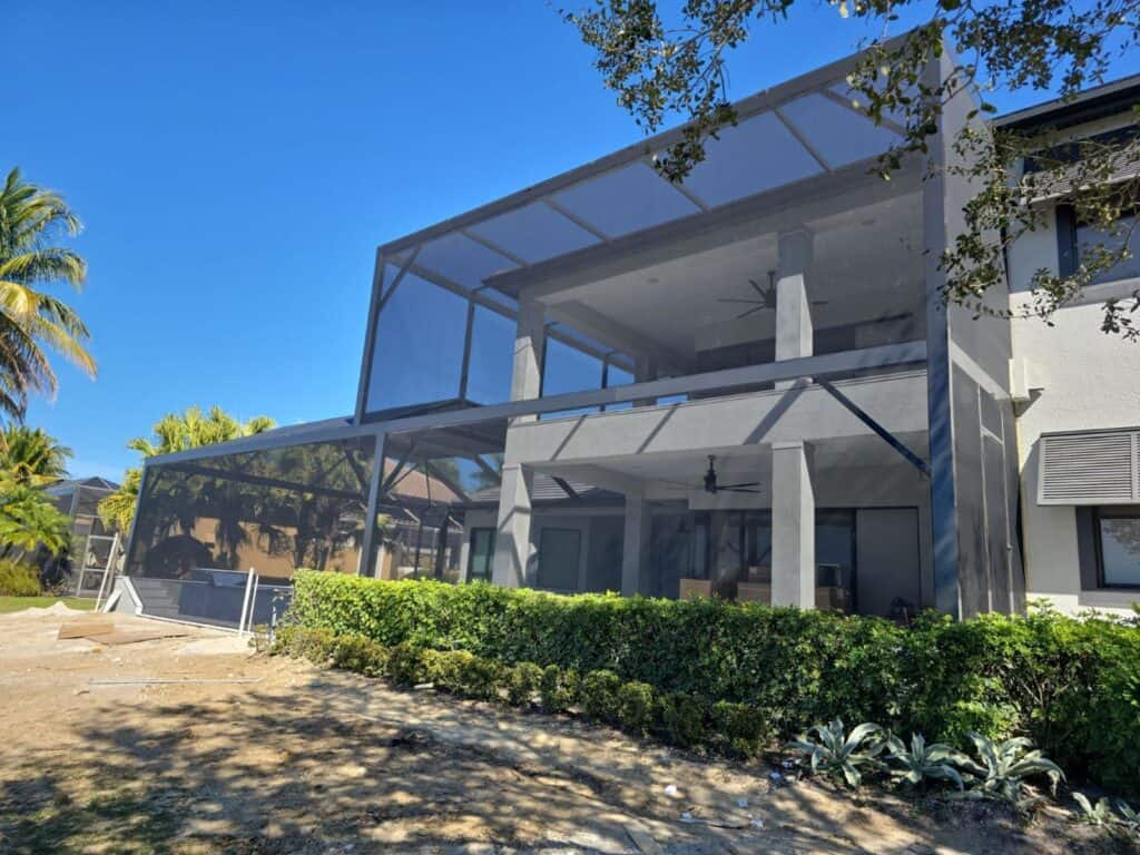 Exterior view of a two story to single story pool cage enclosure in Fort Myers Florida