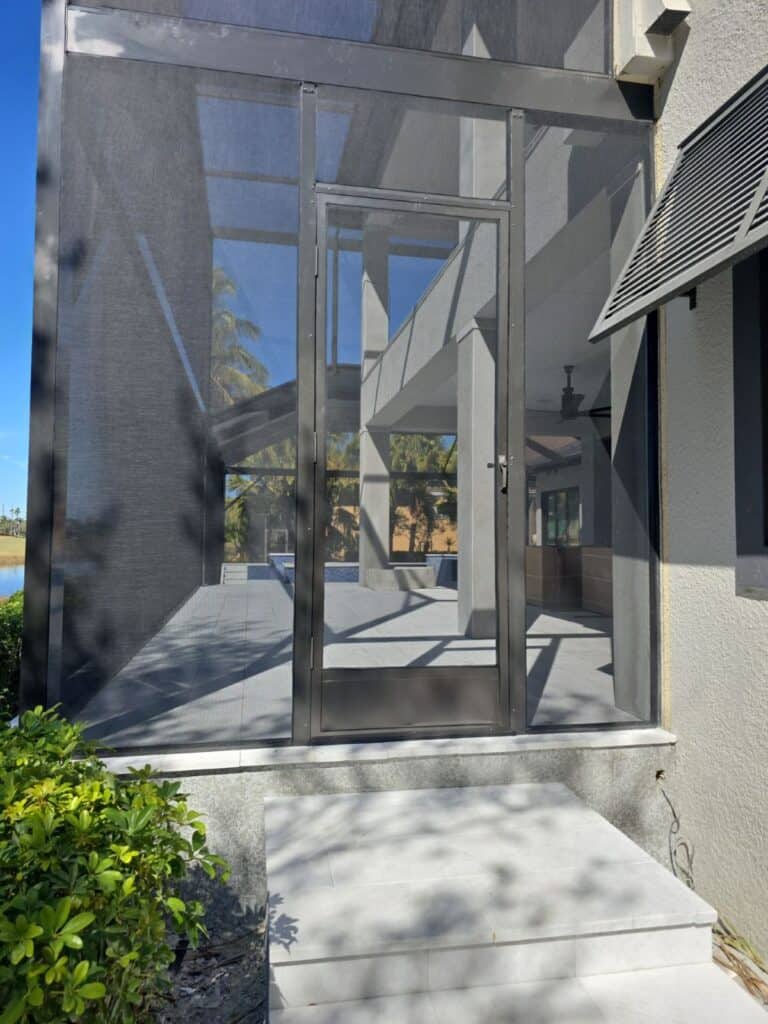 Welded aluminum screen door installed on a custom pool enclosure by a licensed aluminum contractor in Fort Myers, Florida