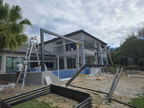 Custom pool cage construction with scaffolding at Fort Myers waterfront home