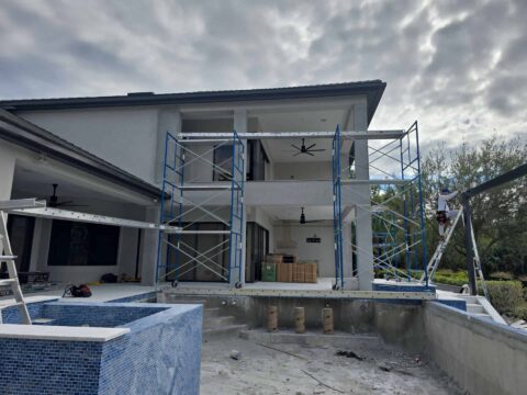 Aluminum screen enclosure frame being installed on two-story home in Fort Myers Florida
