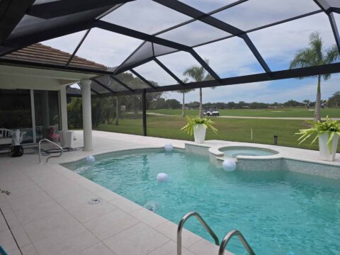 Swimming pool and spa inside aluminum screen enclosure Naples Florida