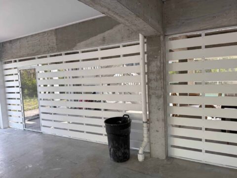 White aluminum privacy panels installed under elevated coastal home on Sanibel Island Florida