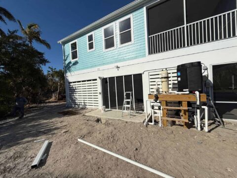 Screen enclosure and aluminum privacy panels installed at elevated coastal home Sanibel Island Florida