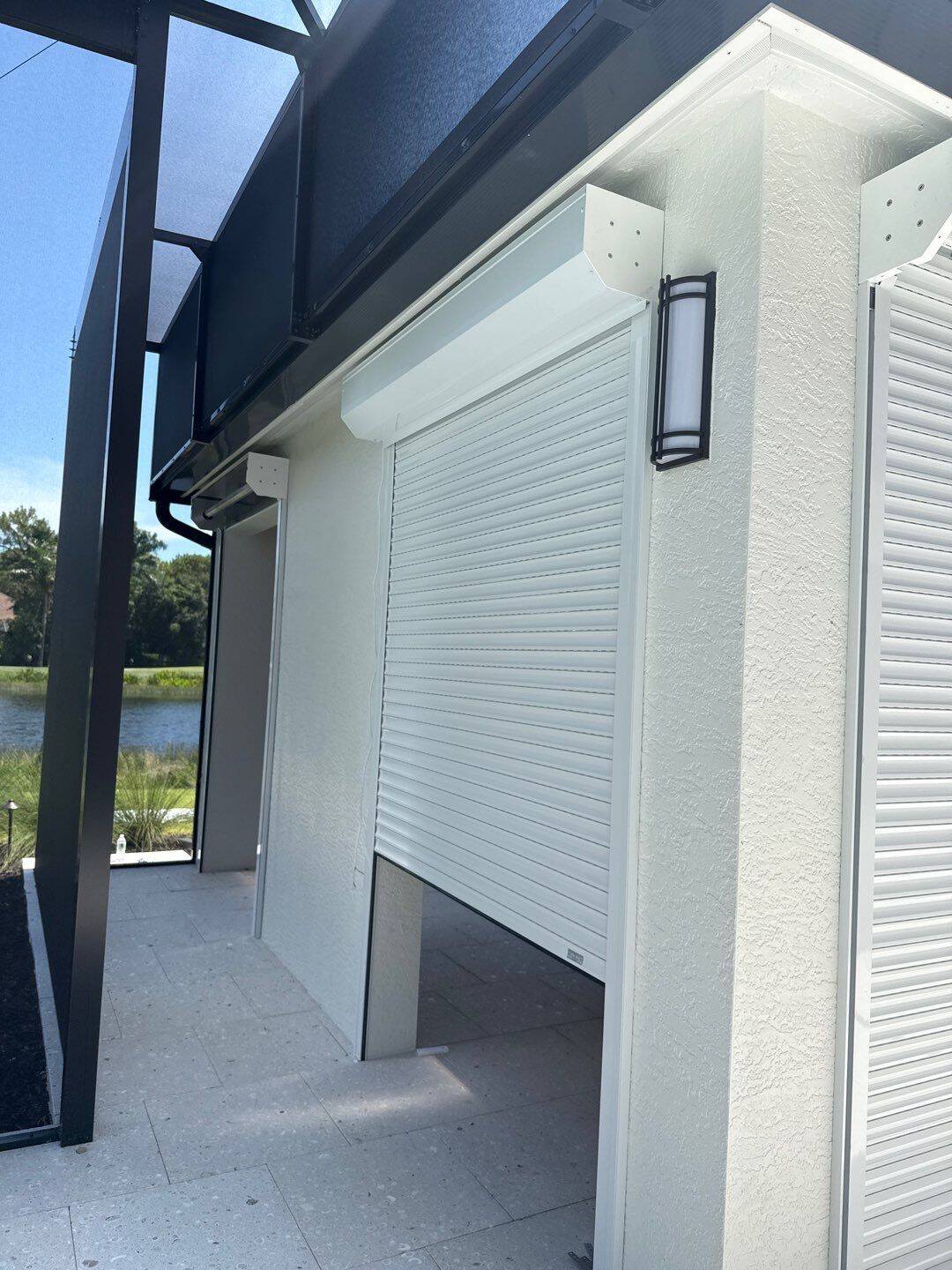 Closed white roll-down hurricane shutter installed on the exterior of a Southwest Florida home overlooking a golf course — SAS Aluminum