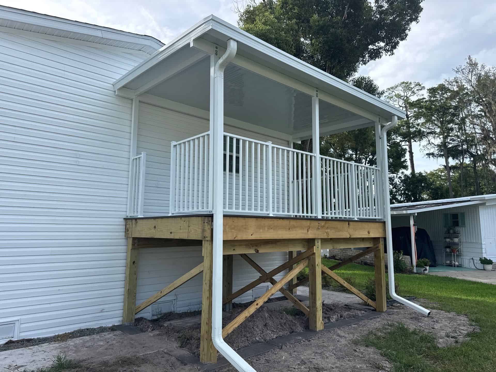 White aluminum pan roof and railing around a raised manufactured-home porch in Port Orange, Florida.